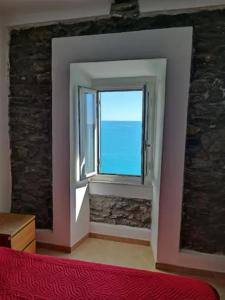 una camera da letto con finestra affacciata sull'oceano di affittacamere nuova Vandiris a Manarola