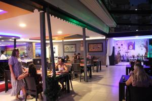 a group of people sitting at tables in a restaurant at Max Nova Hotel in Alanya