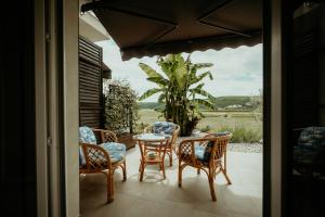 a patio with chairs and a table with a view at B&B Sobe Lušina in Sečovlje