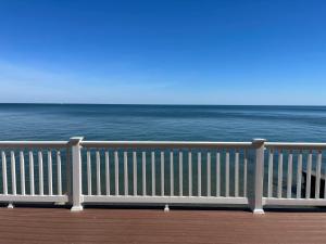a white railing on a boardwalk near the ocean at Pete's Lakefront Motel, LLC in Geneva