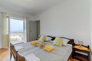 Un dormitorio con una cama con almohadas amarillas. en Apartman Sunce, en Senj