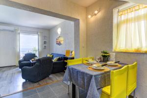 comedor con mesa y sillas amarillas en Apartman Sunce, en Senj