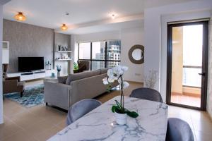 uma sala de estar com uma mesa com flores em Spacious 2 BR with Amazing Marina View Rimal JBR no Dubai