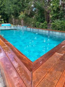 einen Pool mit blauem Wasser und eine Holzterrasse in der Unterkunft La tanière de Bonneville in Bonneville-sur-Touques