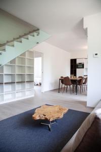 a living room with a wooden table on a blue rug at Villa Umberto in San Giovanni in Marignano +29 photos
