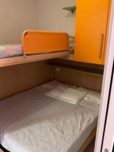 an orange bunk bed in a small room at Villaggio dei Fiori Apart- Hotel 4 Stars - Family Resort-Petz Friendly-With Hypermarket-Delivery Restaurant-Pizzeria-With Breakfast Room with Supplement in Caorle