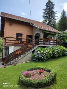 una casa con balcón con flores en el patio en Apartman Jovanovic-Rudnik en Rudnik