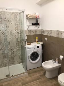 bagno con lavatrice e servizi igienici di BrothersHouse a Cefalù