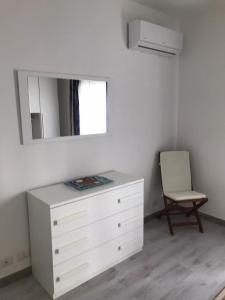 una camera da letto con cassettiera, specchio e sedia di BrothersHouse a Cefalù