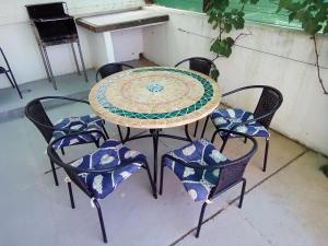 a patio table with four chairs with blue and white tiles at Apartman Pavic in Pag +29 photos