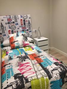 1 dormitorio con 1 cama con colcha colorida en Playa del Sardinero ZonaHotelReal en Santander