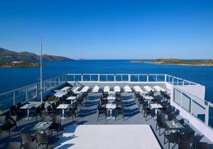 a deck of a cruise ship with tables and chairs at Mistral Bay Hotel in Agios Nikolaos