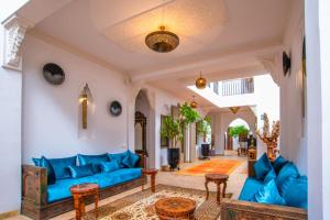 Riad la clé d'or & spa في مراكش: غرفة معيشة مع الأرائك الزرقاء والطاولات