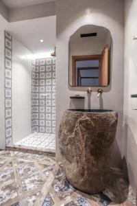 baño con lavabo de piedra y espejo en Meteora Heaven and Earth Kastraki premium suites - Adults Friendly, en Kalambaka
