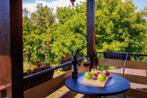 a table with a glass of wine and fruit on a balcony at Apartmani Nina in Golubac