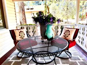 a table and chairs on a porch with a vase on it at Hidden Gem Retreat in the Heart of Payson in Payson