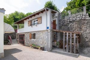 a stone house with a balcony on top of it at Idyllic Holiday House For Two in Rukavac