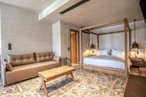 a bedroom with a bed and a couch at Meteora Heaven and Earth Kastraki premium suites - Adults Friendly in Kalabaka