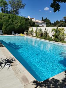 a swimming pool in front of a house at Roulotte HOPE-Le jardin de Mia in Paradou