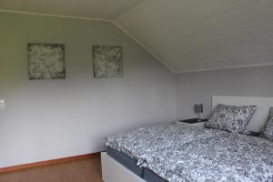 ein Schlafzimmer mit einem Bett und zwei Bildern an der Wand in der Unterkunft Ferienwohnung Eifelbrise in Nideggen