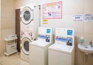 a laundry room with a washing machine and a sink at Hotel New Palace in Shingu