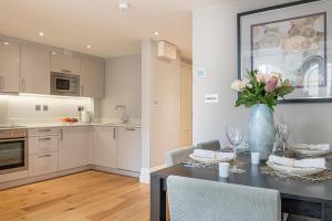 a kitchen with a table with a vase of flowers on it at Bath Circle in Bath