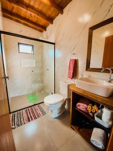 a bathroom with a toilet and a sink and a shower at Casa Container - Pousada Container da Montanha VERDE Banheira in Rio Fortuna