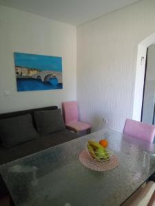 a living room with a table with a bowl of fruit on it at Apartman Pavic in Pag