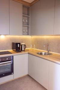 a kitchen with white cabinets and a sink at Vertmont Villa in Sveti Stefan