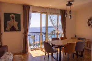 een eetkamer met een tafel en uitzicht op de oceaan bij Vertmont Villa in Sveti Stefan