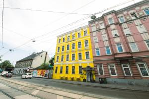 um edifício amarelo no lado de uma rua em Hotel California em Viena