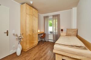 a bedroom with a bed and a desk and a window at Hotel aanders in Neumünster