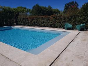 a swimming pool with two chairs next to it at Appartement 2 pers avec accès piscine in Saint-Rémy-de-Provence +4 photos