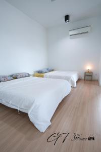 Duas camas brancas num quarto com piso em madeira em GT Home @ Sunway Nexis em Petaling Jaya