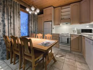 a kitchen with a wooden table and chairs at Economy Lomailevi in Levi +17 photos