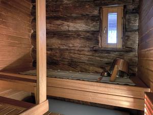 a room with a bed in a wooden cabin with a window at Economy Lomailevi in Levi