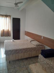 a bedroom with two beds and a couch at Pousada Aliança in Aparecida