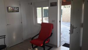 a red chair sitting in a room with a door at casadelfenix in Alicante