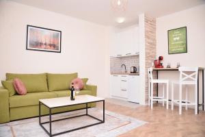 a living room with a green couch and a table at Apartments Siesta in Ivanica