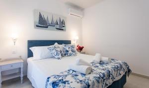 Schlafzimmer mit einem Bett mit blauer und weißer Bettwäsche in der Unterkunft oliva e mare luxury suite in Korfu-Stadt