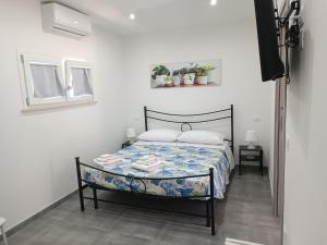 een slaapkamer met een bed in een kamer bij Appartamenti Mamma Marisa in Minturno