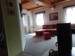 a living room with a red couch and a table at Ubytování U Sviráků in Srbská Kamenice