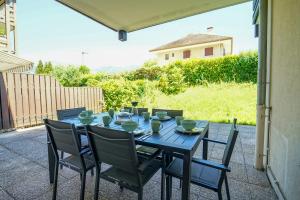 a blue table and chairs on a patio at Le Poisson Vert apartment 6 people 200m from the beach of Sevrier! in Sévrier