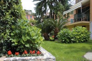 聖馬爾蓋里塔利古雷的住宿－Casa del Tempo, apt+giardino CITRA 010054-LT-0417，一座花园,在一座建筑前种有植物和花卉