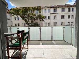 a chair on a balcony with a view of a building at TomsFlat BRAUNSCHWEIG - 3 ROOMS, KITCHEN, WORKSPACE, HIGHSPEED WIFI, WASHER & DRYER, BALCONY in Braunschweig