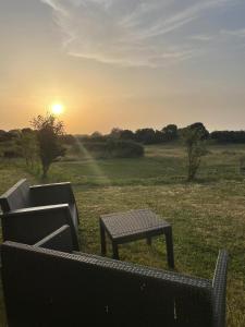 a table and a bench in a field with the sunset at Don Pablo in Pechón