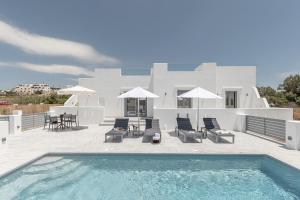 a villa with a swimming pool in front of a house at Sand & Sea Private Pool Villa Agia Anna in Agia Anna Naxos