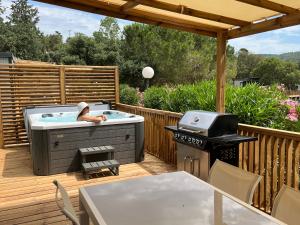 a hot tub on a deck with a grill at Domaine de Miremer in La Garde-Freinet
