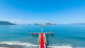 a dock in the water with a group of people on it at Lykia Botanika Beach Fun & Club - All Inclusive in Fethiye