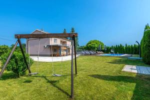 a yard with a swing in front of a house at Large apartment in Central Istria with private pool in Pulići